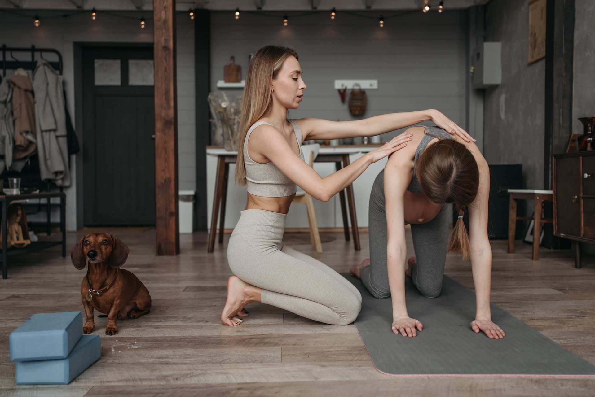 Female trainer guiding a client through a stretch during a session